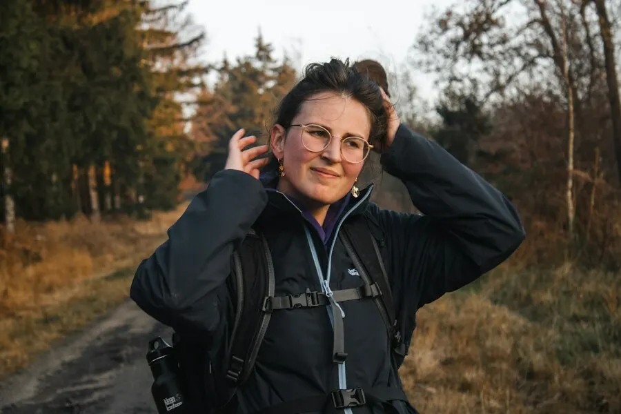 Smiling woman in her forties on a hiking trail in autumn